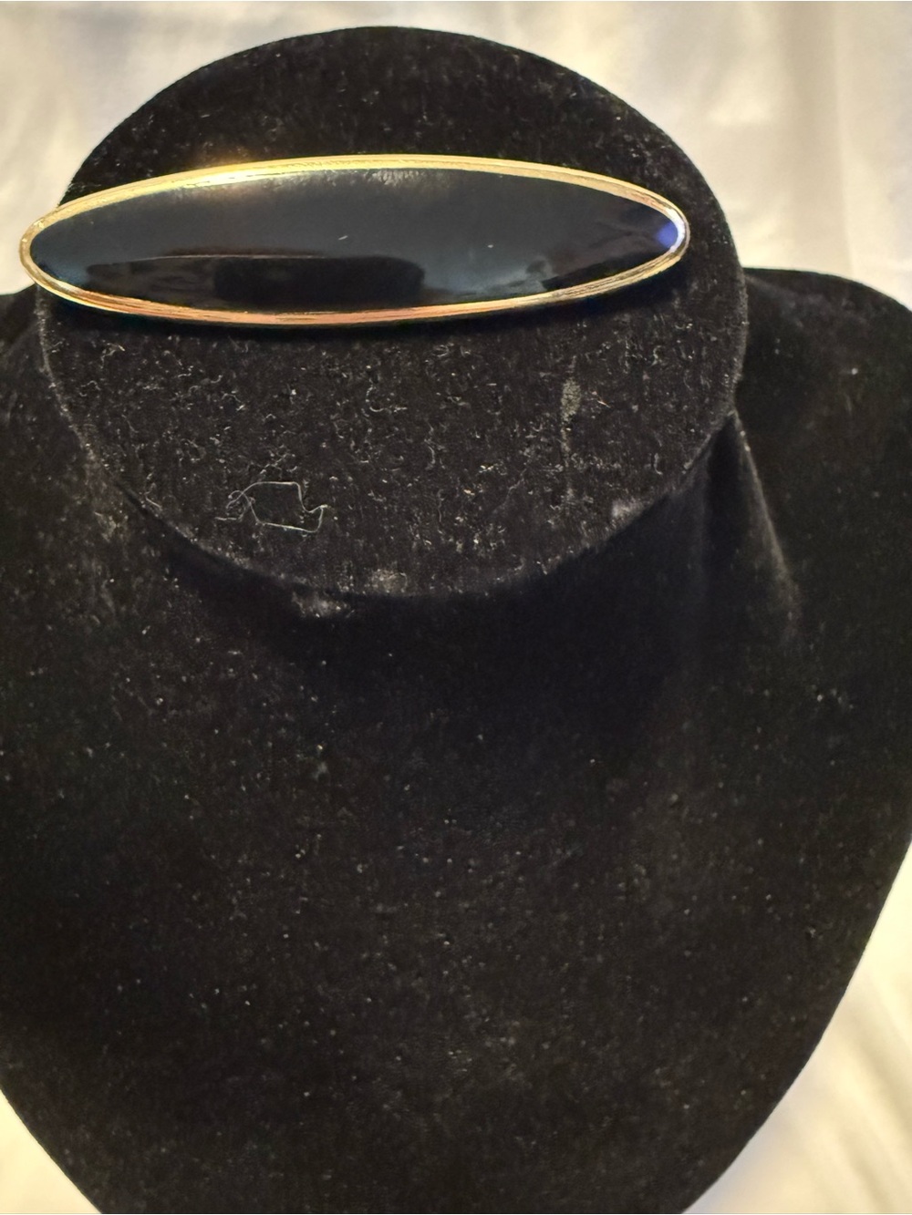 vintage Monet brooch w/sleek, black enamel center framed in polished gold tone